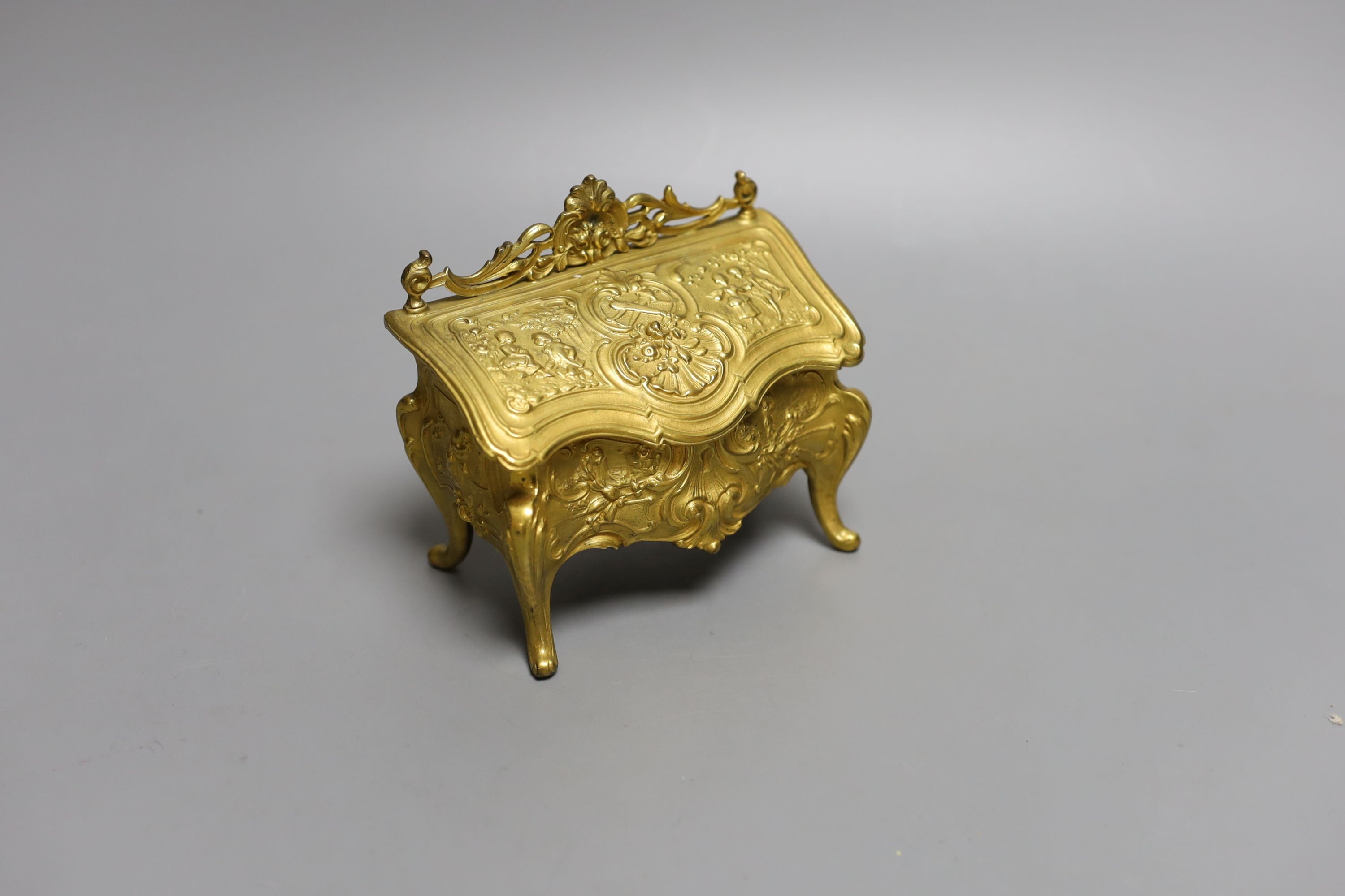 A novelty gilt metal, serpentine shaped miniature chest inkwell and a similar urn shaped inkwell, Chest 11 cms wide.